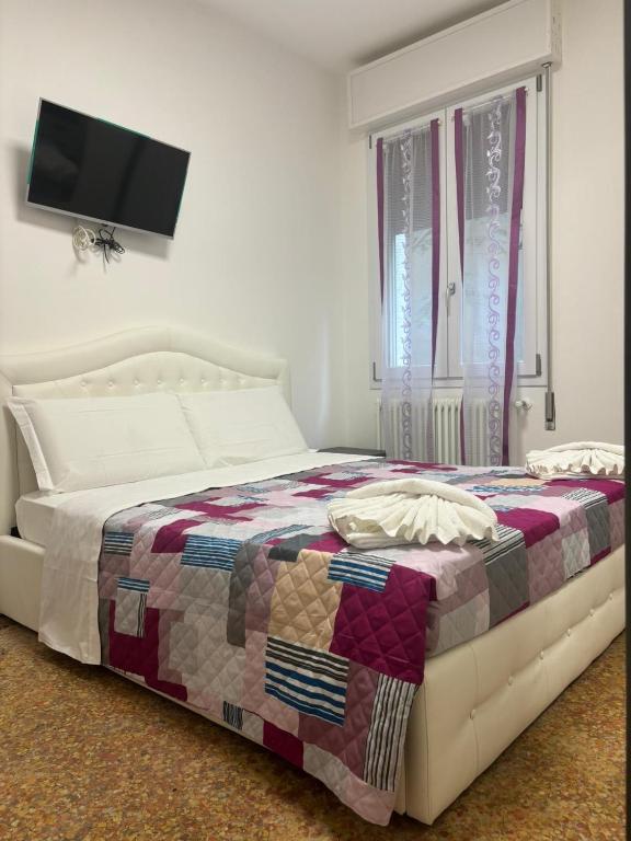 a bed with a quilt on it in a bedroom at Venice Station Guest House in Mestre
