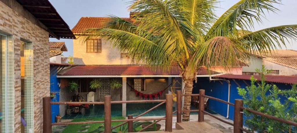 ein Haus mit einer Palme auf einer Veranda in der Unterkunft Chalé Vovó Zezé in Bertioga