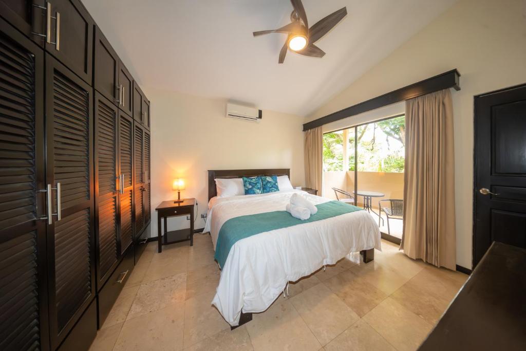 a bedroom with a bed and a ceiling fan at The Cove Door 15 and 16 Upper & Lower Unit in Ocotal