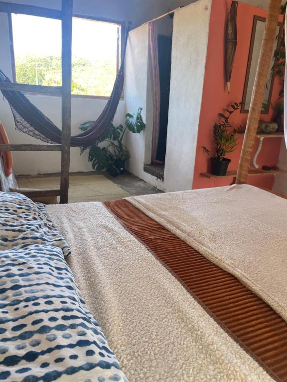 1 dormitorio con 1 cama y 1 hamaca en Hospedagem Toca das lobas, en São Thomé das Letras