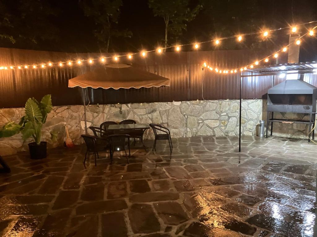 a patio with a table and chairs and lights at Yan House in Ijevan