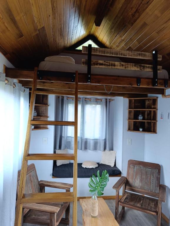 Letto a castello in una camera con tavolo e sedie di Tiny House Nativa a Montecarlo