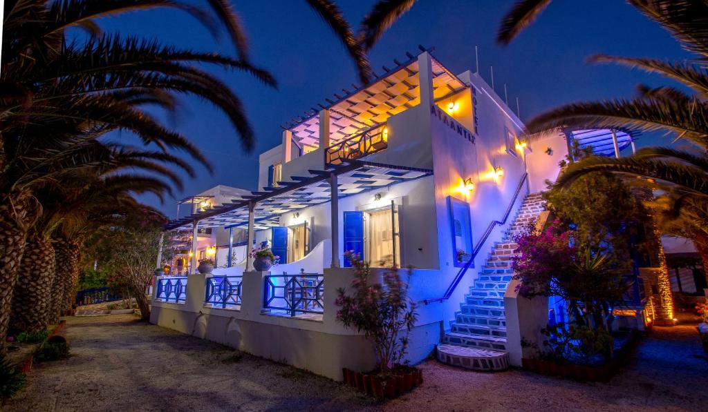 ein weißes Haus mit Palmen davor in der Unterkunft Syros Atlantis in Vári