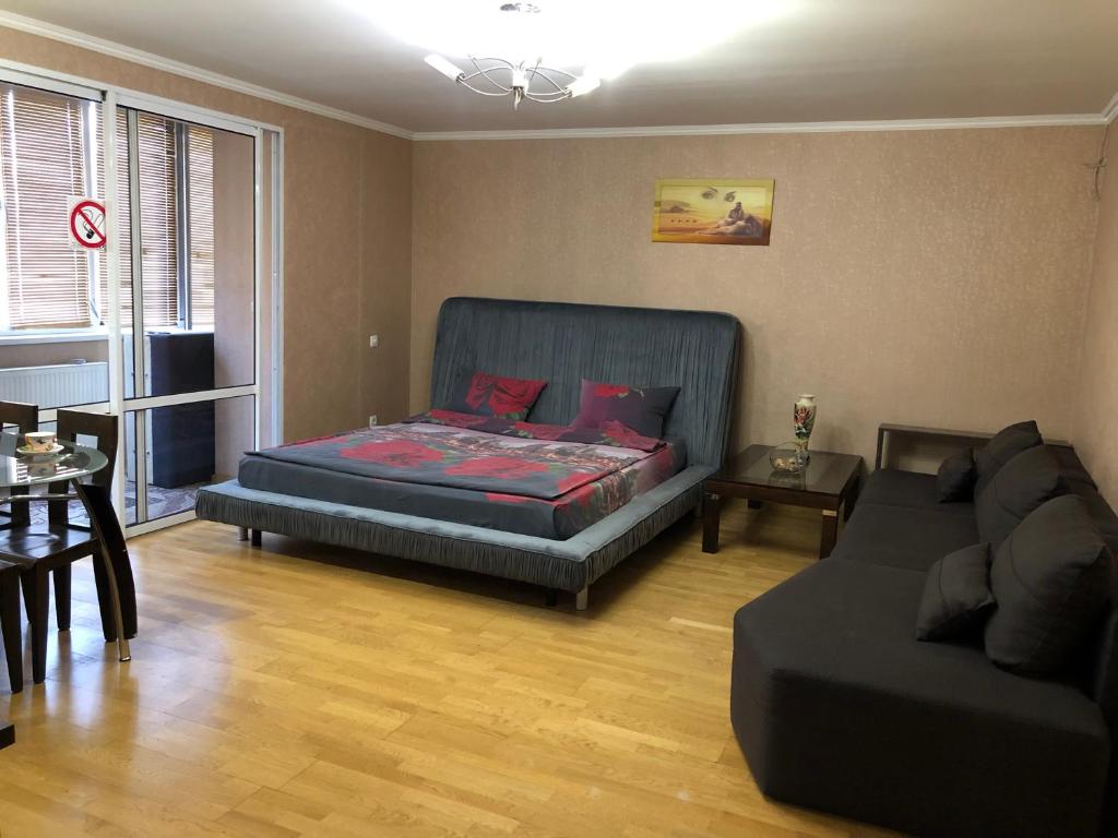 ein Wohnzimmer mit einem Bett und einer Couch in der Unterkunft 1 комнатная квартира студио возле ТРЦ Днепроплаза in Tscherkassy