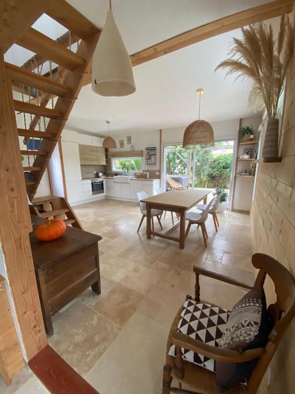 Il comprend une grande cuisine et une salle à manger avec une table. dans l'établissement Maison des conches, à Longeville-sur-Mer