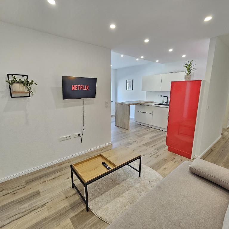 Una sala de estar con un sofá y un televisor en una pared. en Ziegel-Quartier APTNR 2, en Viersen