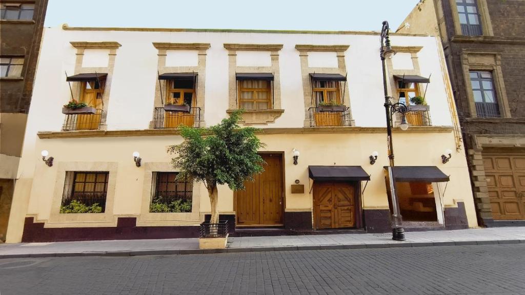 a building with windows and doors on a street at Casa Donceles Apartments and Suites, Alojamientos ideales para familias y grupos in Mexico City