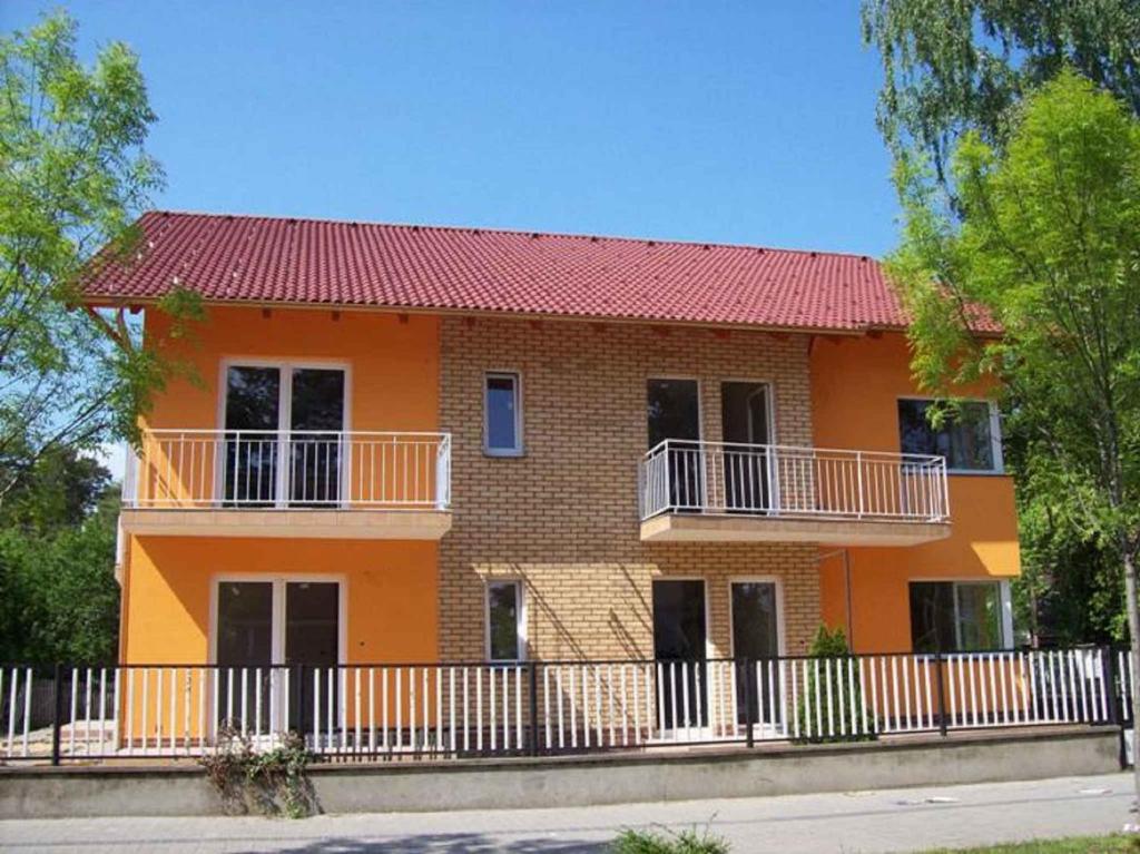 duży pomarańczowy dom z czerwonym dachem w obiekcie Apartments in Siofok/Balaton 35466 w Siófoku