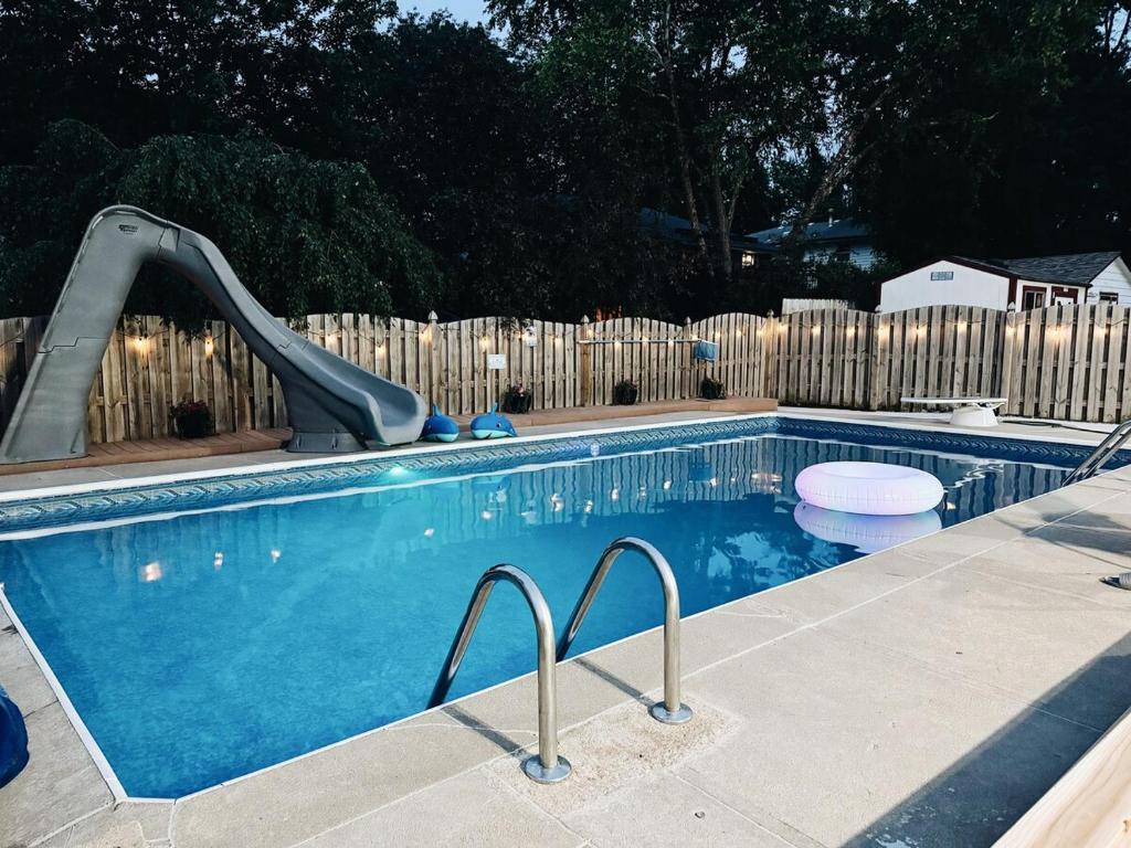 a swimming pool with a slide in front of a fence at Newly Renovated Home With Pool in Omaha