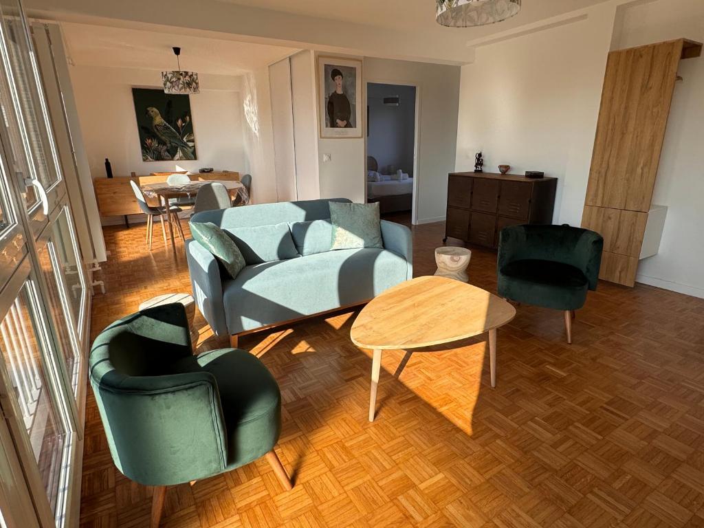 un salon avec un canapé, des chaises et une table dans l'établissement l'emeraude de Nanterre, à Nanterre