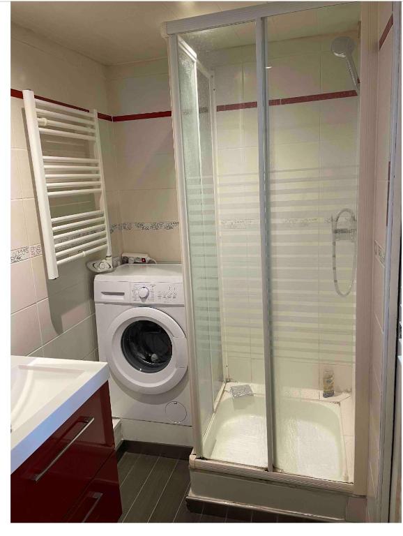 une salle de bain avec une machine à laver et un lave-linge dans l'établissement Appartement calme, à Saint-Valery-en-Caux