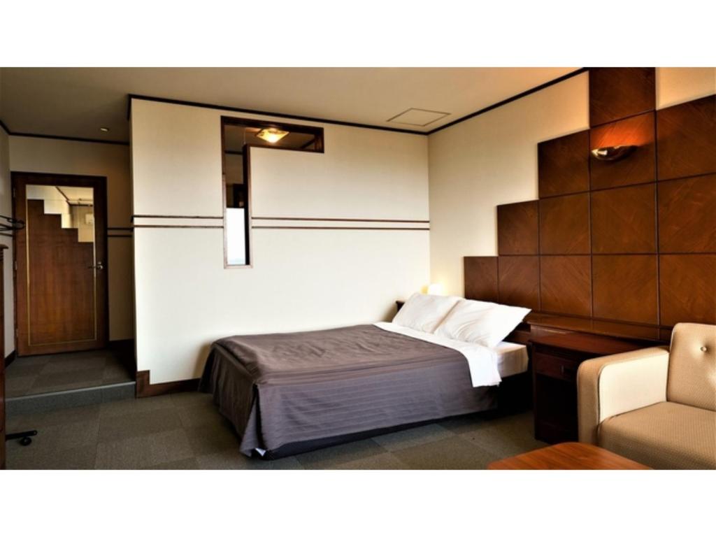 a hotel room with a bed and a chair at Ｐｕｒａｒｉ - Vacation STAY 81759v in Takahara