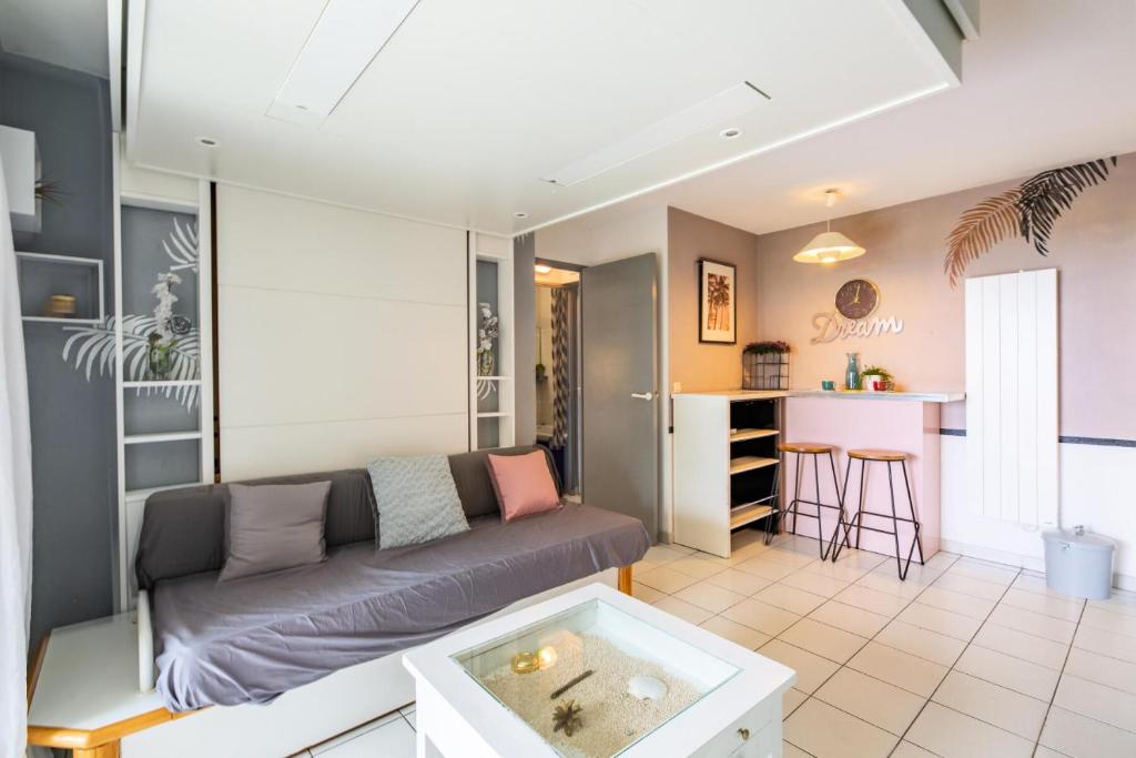 un salon avec un canapé et une cuisine dans l'établissement Résidence le Village de Cap Esterel - maeva Home - Appartement vue mer 2 pièces 4 personnes - Confort MAE-9963, à Saint-Raphaël