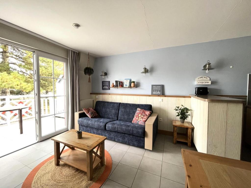 a living room with a blue couch and a table at Résidence Belle Dune - maeva Home - Appartement chaleureux 2 pièces 4 personnes - Prestige MAE-8313 in Fort-Mahon-Plage