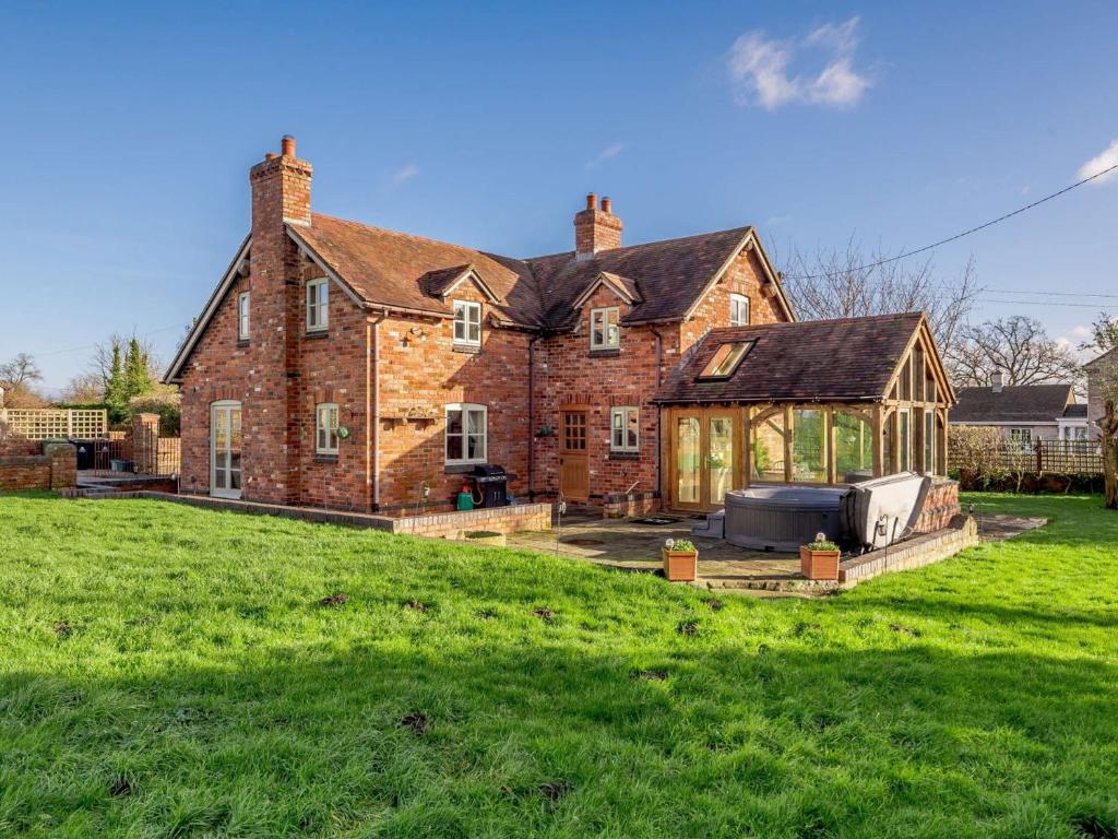 a large brick house with a greenhouse in the yard at 4 Bed in Blakeney 90589 in Awre