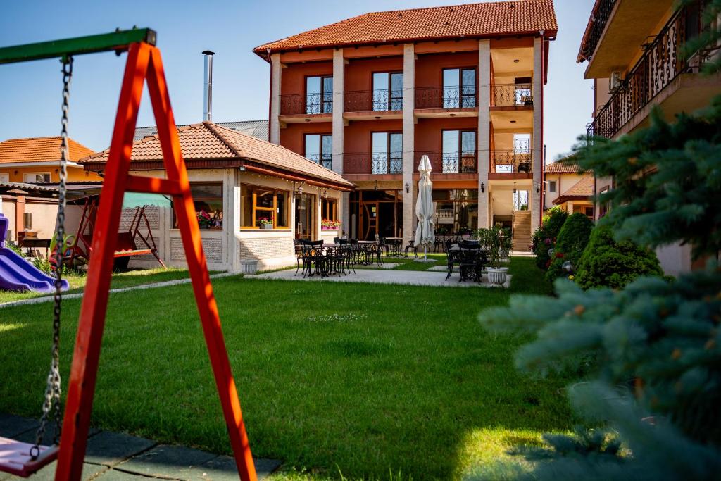 a playground in a yard with a building at Casa Soarelui in 2 Mai