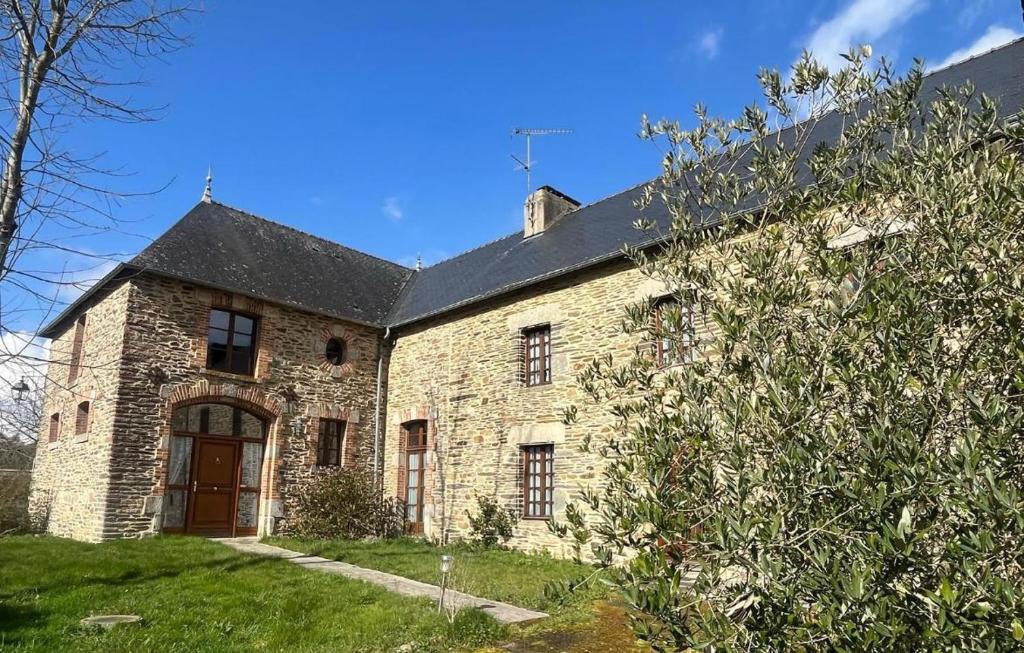 une ancienne maison en pierre avec un toit noir dans l'établissement Le clos de Brocéliande, à Caro