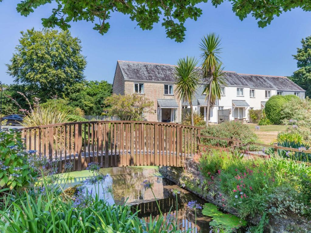 un jardín con un puente de madera frente a una casa en 3 Bed in Falmouth 89103, en Budock Water