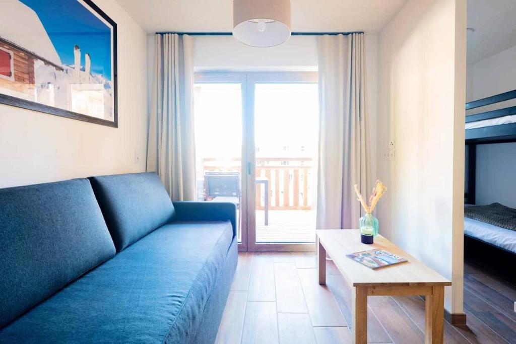 a living room with a blue couch and a table at Appartement 3 Pièces 6 Personnes MAE-4333 in Vars