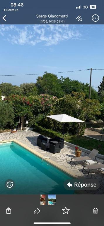 une photo d'une piscine avec un parasol et des chaises dans l'établissement Studio indépendant calme pas loin du centre, à Nîmes