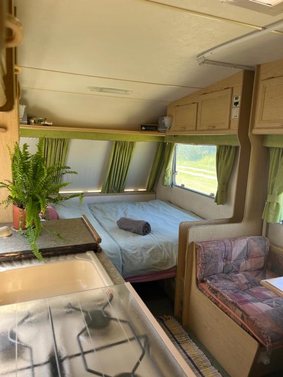 a small room with a bed and a tub in a rv at Vintage Nest by the Sea in Saraiķi