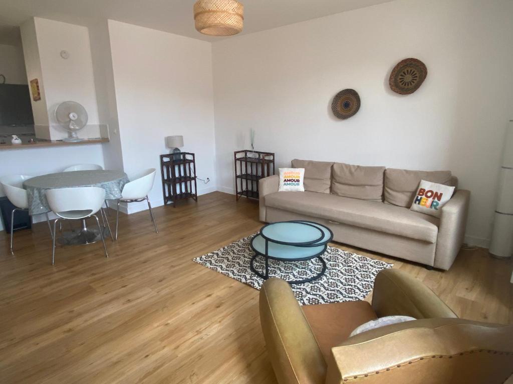 un salon avec un canapé et une table dans l'établissement Appartement cosy dans la bastide, à Sainte-Foy-la-Grande