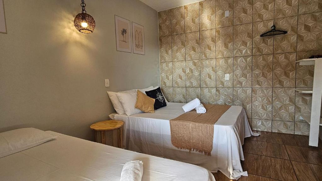 En eller flere senge i et værelse på Suítes Recanto Praia Grande