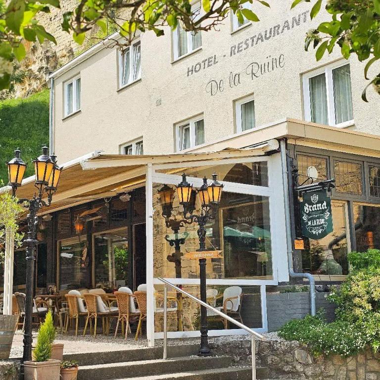a restaurant with tables and chairs in front of a building at Herberg de la Ruïne in Valkenburg