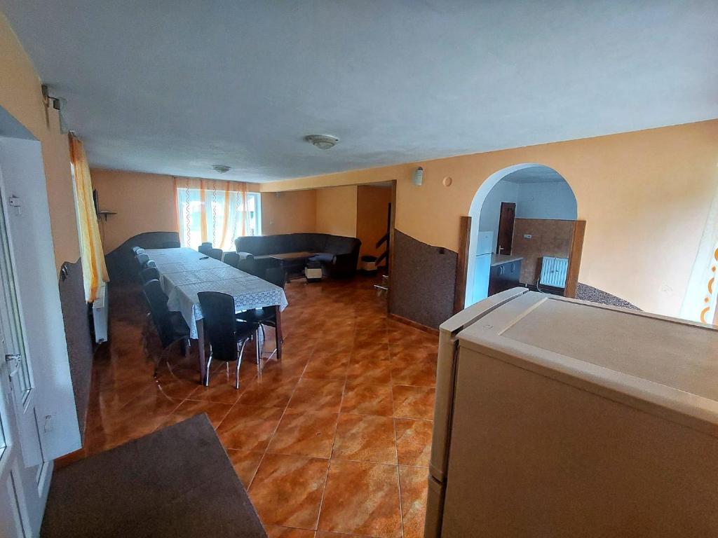 ein Raum mit einem langen Tisch und Stühlen und ein Raum mit einem Tisch in der Unterkunft Cabana Elena in Izlaz