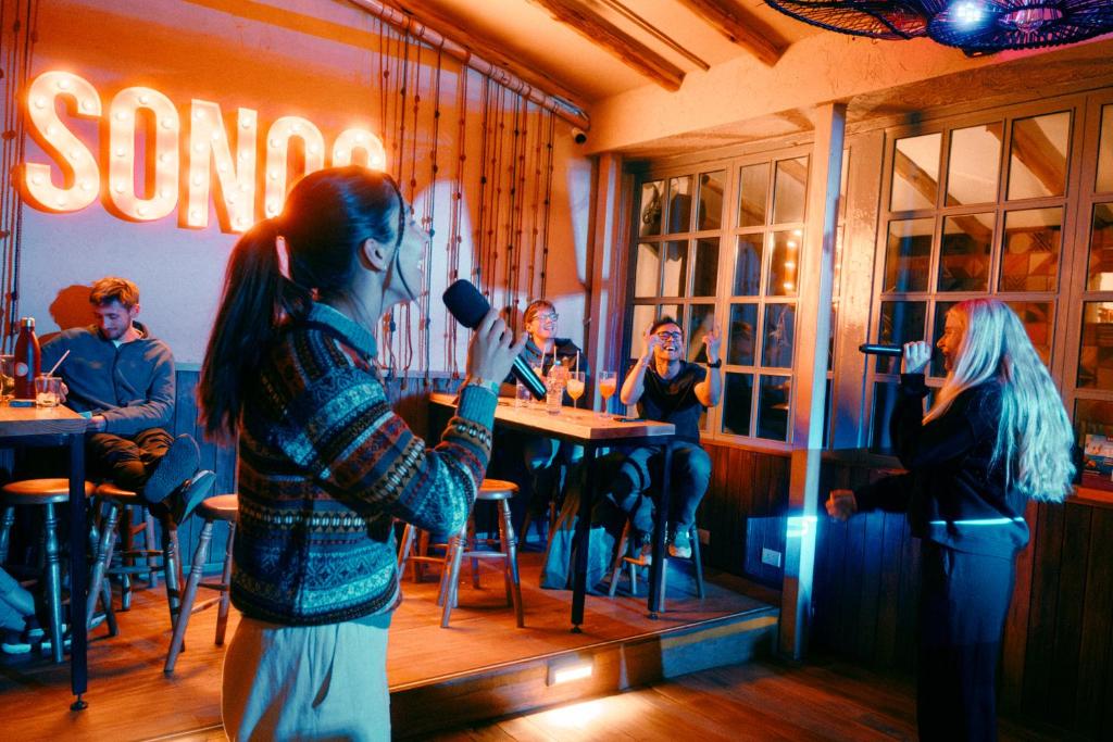 a woman standing in a restaurant holding a microphone at Viajero Cusco Hostel in Cusco