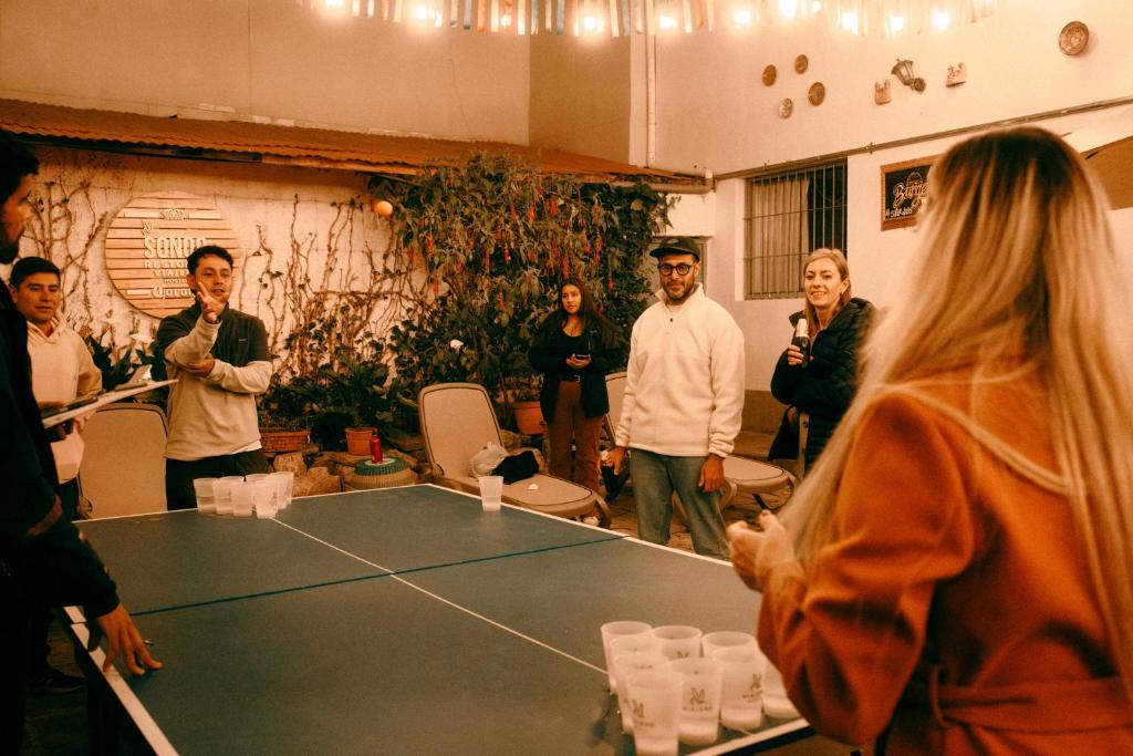 a group of people standing around a ping pong table at Viajero Cusco Hostel in Cusco