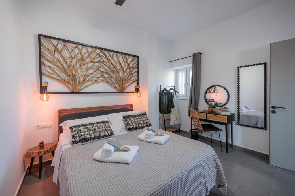 Un dormitorio con una cama con dos toallas encima. en Stonehill Suites Ano Syros, en Ano Syros