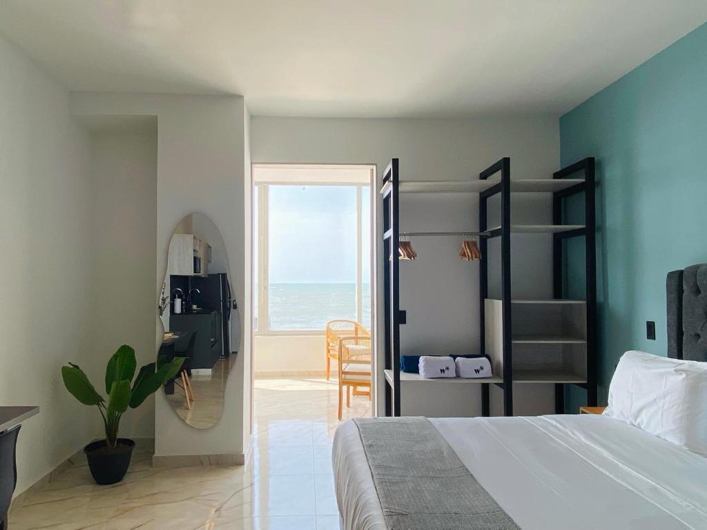 a bedroom with a bed and a view of the ocean at Muralla by Wynwood House in Cartagena de Indias