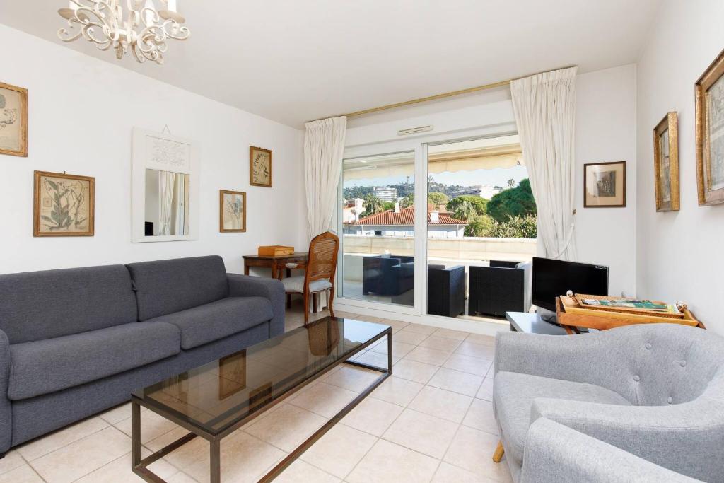 un salon avec un canapé et une table dans l'établissement PALMIER Calme, 2 chambres, 2 salle de bains, 2 wc, clim, Parking, à Cannes