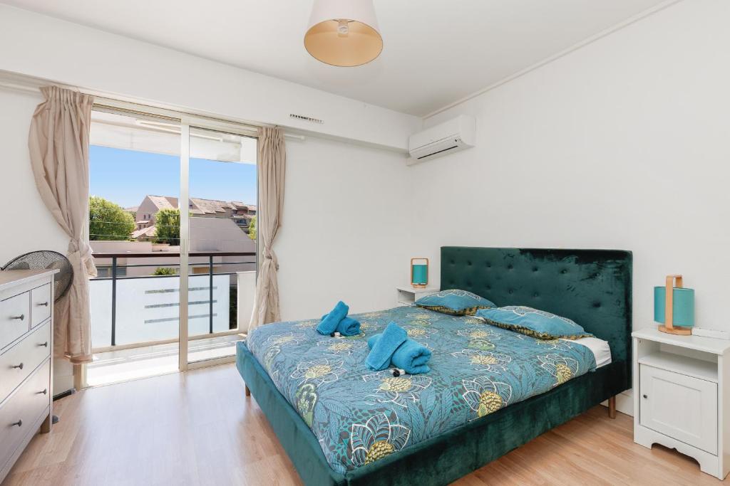 une chambre avec un lit avec des oreillers bleus et une fenêtre dans l'établissement MALTE-Entrée Cap d'Antibes, perle tout confort - Rare, à Antibes