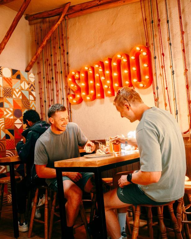two men sitting at a table in a restaurant at Viajero Cusco Hostel in Cusco