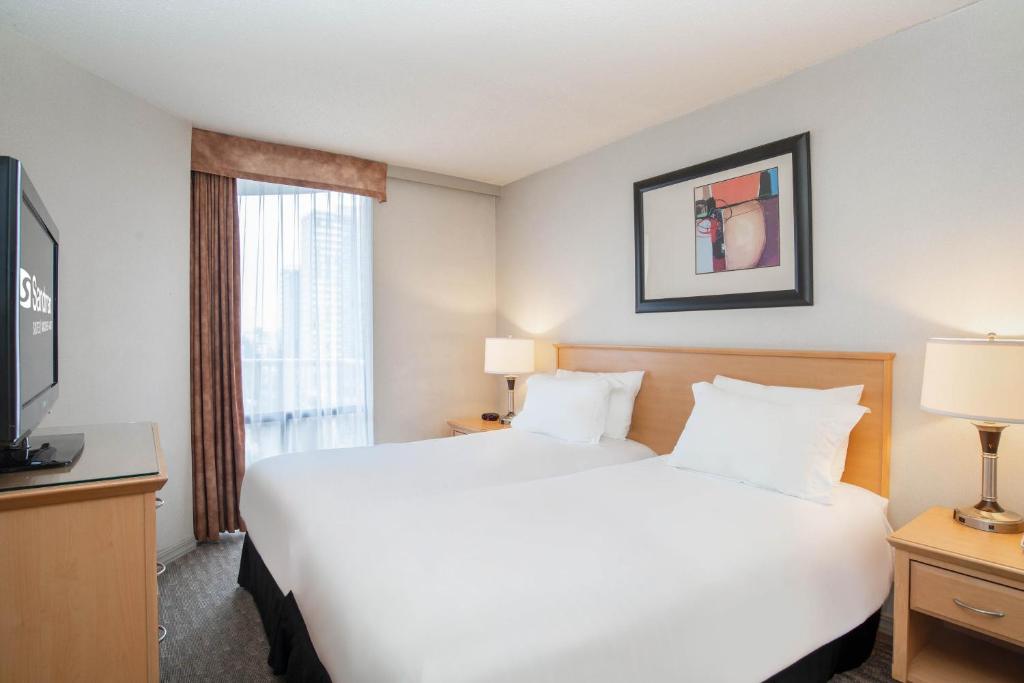 Postel nebo postele na pokoji v ubytování Sandman Suites Vancouver on Davie