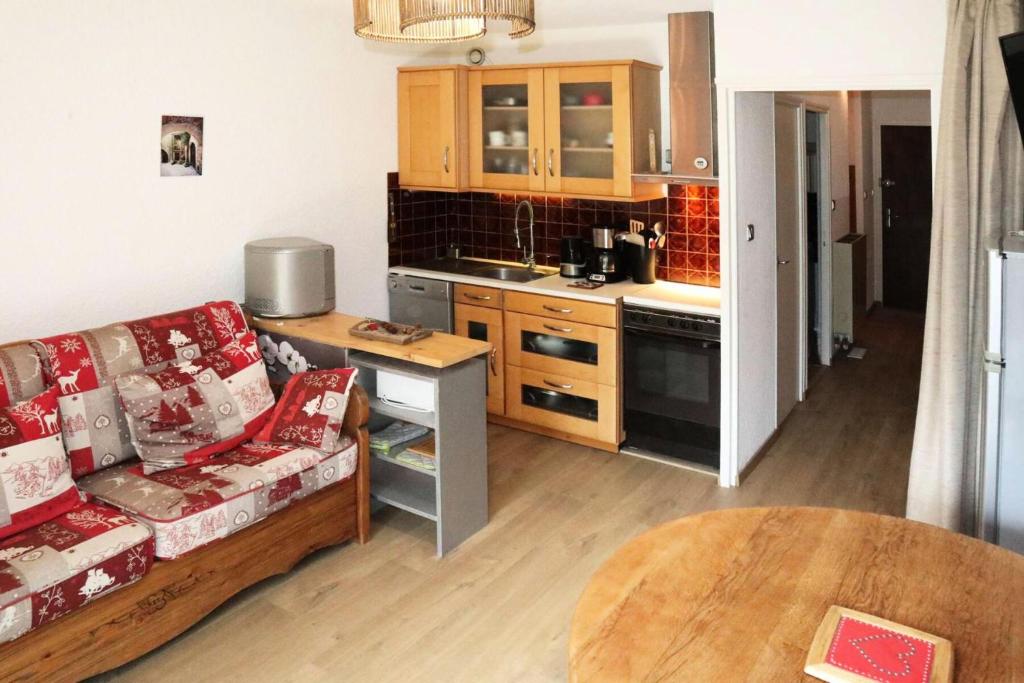 un salon avec un canapé et une cuisine dans l'établissement Résidence Les Ecrins - 403 LES ECRINS STUDIO 5 PERSONNES MAE-2423, aux Orres