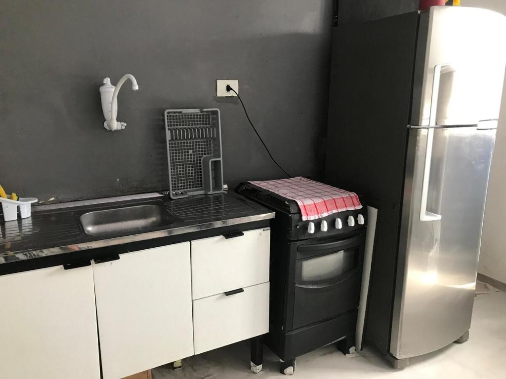 a kitchen with a stove and a refrigerator at Casa na Prainha com banheira,30m do acesso à praia in São Vicente