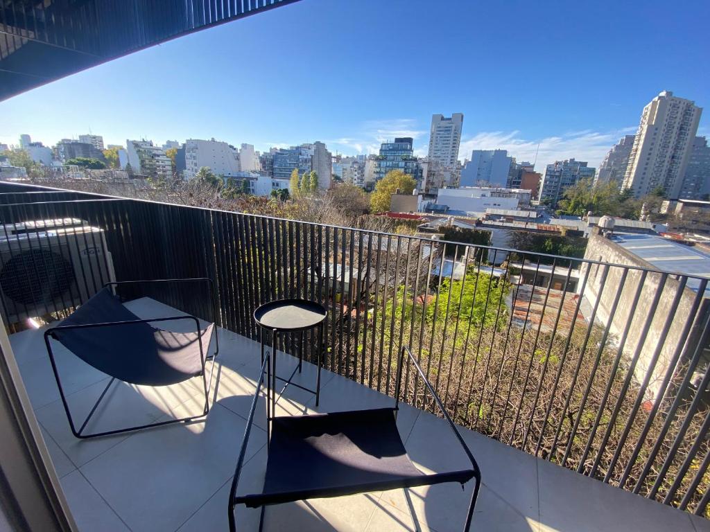 a balcony with two chairs and a view of a city at Apartment in central Palermo, BsAs, full amenities in Buenos Aires