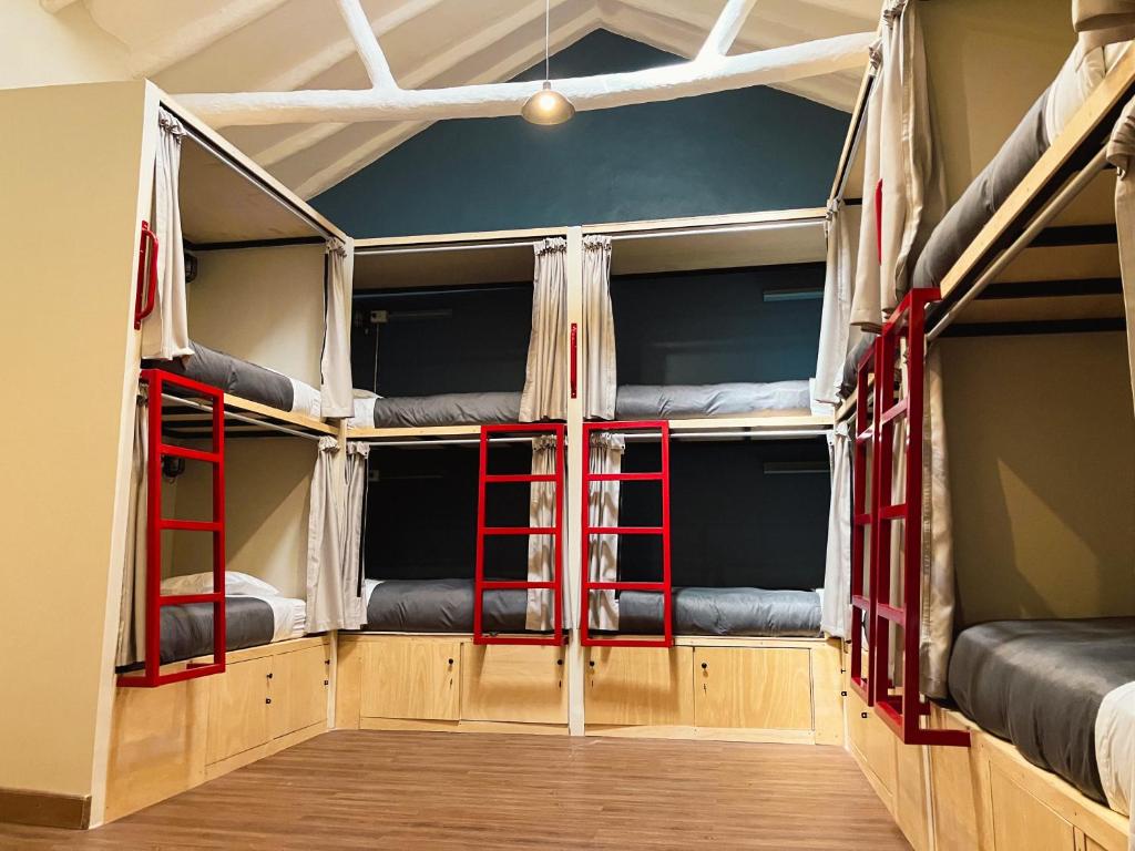 two bunk beds with red frames in a room at Viajero Cusco Hostel in Cusco