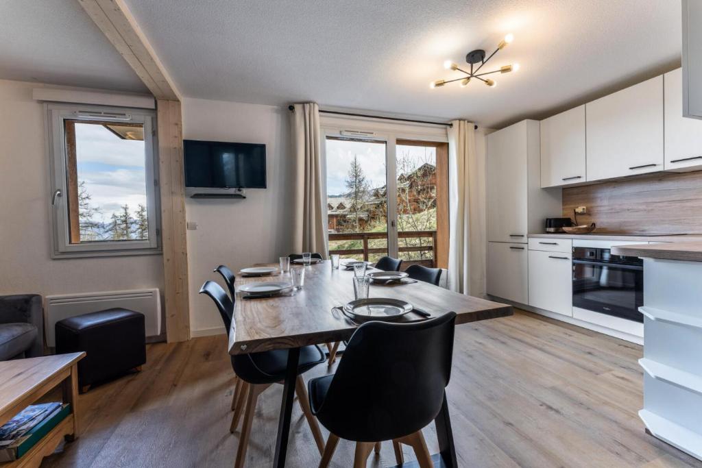 une cuisine et une salle à manger avec une table et des chaises dans l'établissement Les Chalets De Bois MÉan - D - Bel appartement 8 couchages rénové aux Orres 1800 MAE-5894, aux Orres