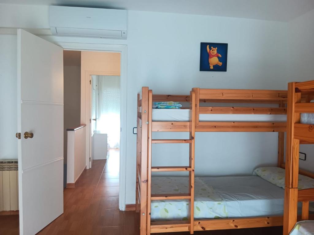 a room with two bunk beds and a hallway at Casa Miami Platja in Miami Platja
