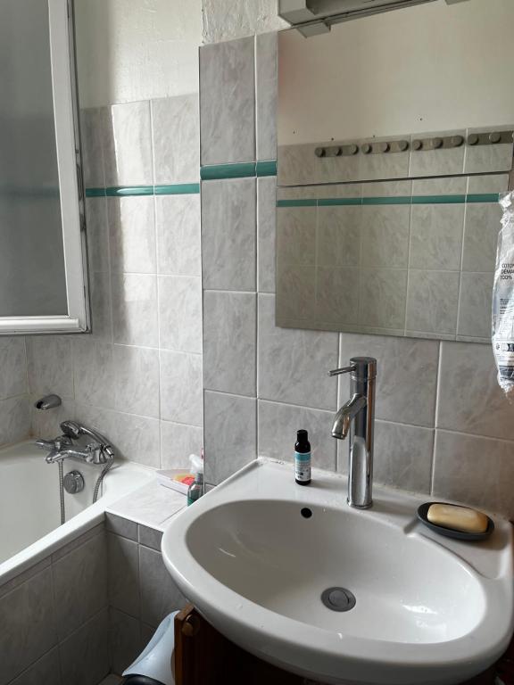 La salle de bains est pourvue d'un lavabo blanc et d'une baignoire. dans l'établissement Chez marie-Cécile, à Vandœuvre-lès-Nancy