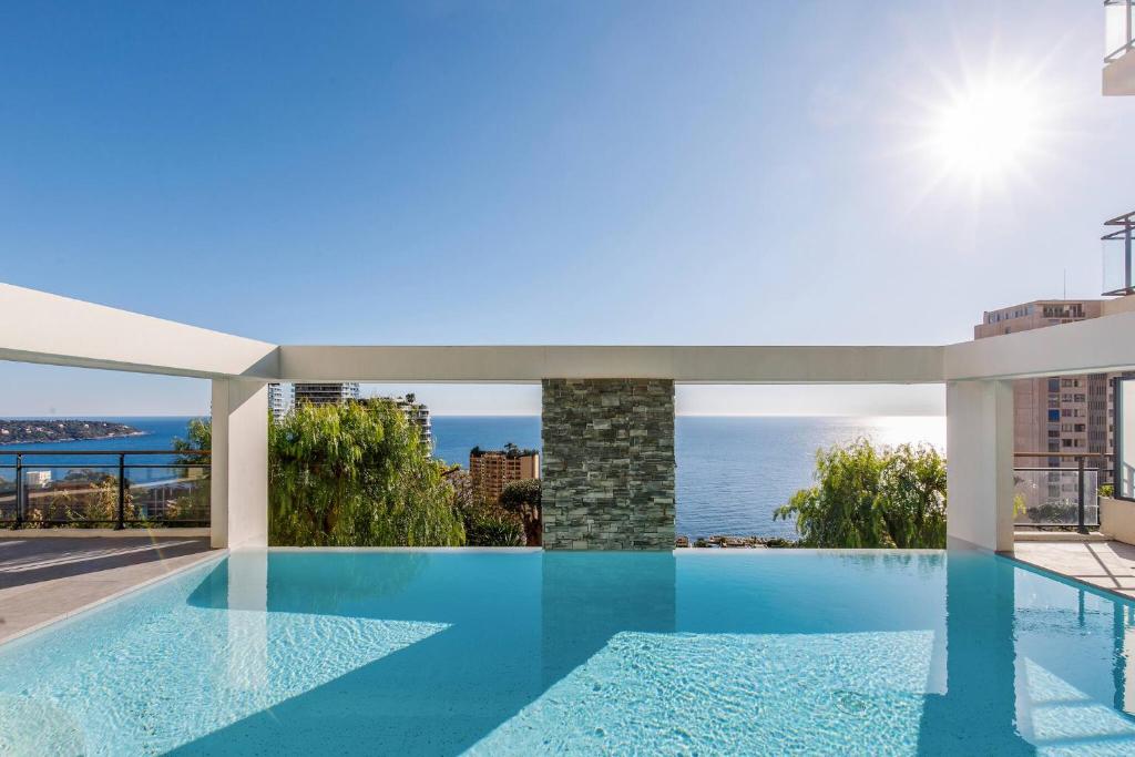 - une piscine dans un bâtiment avec vue sur l'océan dans l'établissement CIPRIANI-Perle rare vue mer proche Monaco, piscine, parking, à Beausoleil