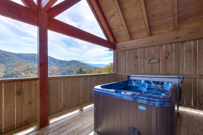 a hot tub in a cabin with a view of the mountains at Lost Horizon by Venture Smoky Mountains in Sevierville