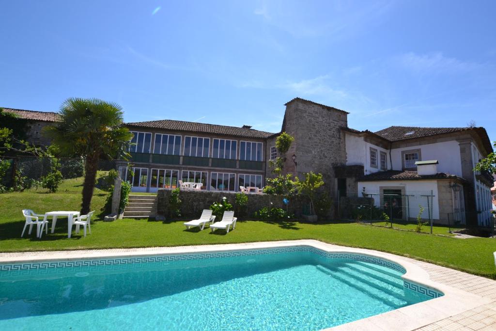 a swimming pool in front of a house at Casa Nobre do Correio-Mor in Ponte da Barca