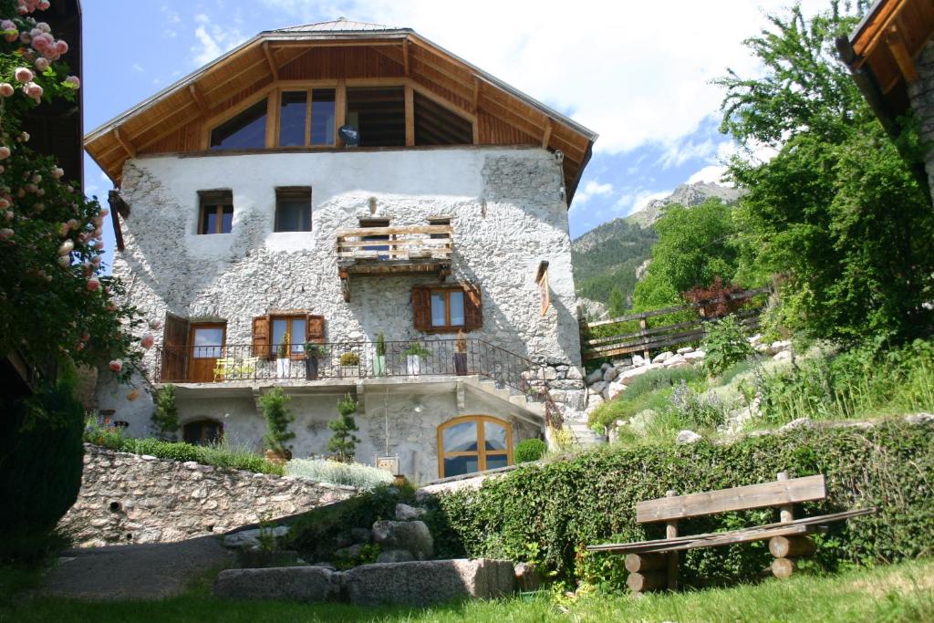 ein Haus auf einem Hügel mit einer Bank davor in der Unterkunft Chambre d'hôtes La Font in Eygliers