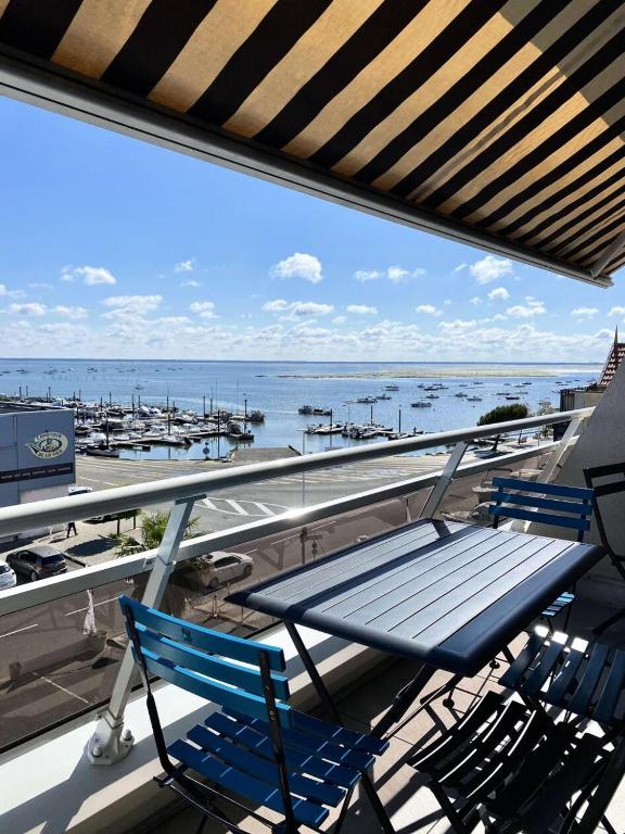 deux chaises et une table sur un balcon avec vue sur l'océan dans l'établissement Résidence Les Huniers - Charmant T3 avec vue imprenable sur le bassin d'Arcachon MAE-9574, à Arcachon