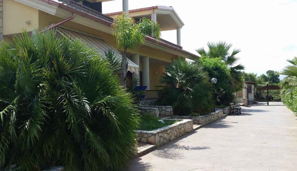 een gebouw met palmbomen naast een stoep bij Green Park Residence in Foce Varano
